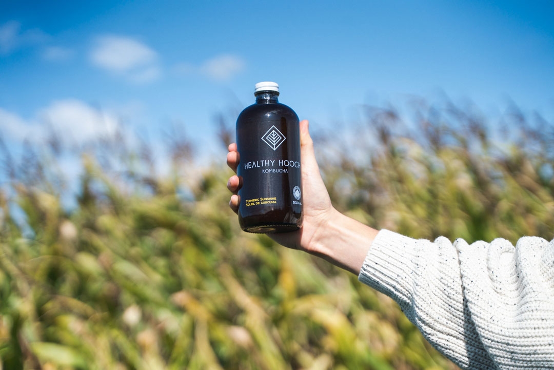 bottle of healthy hooch in front of a field