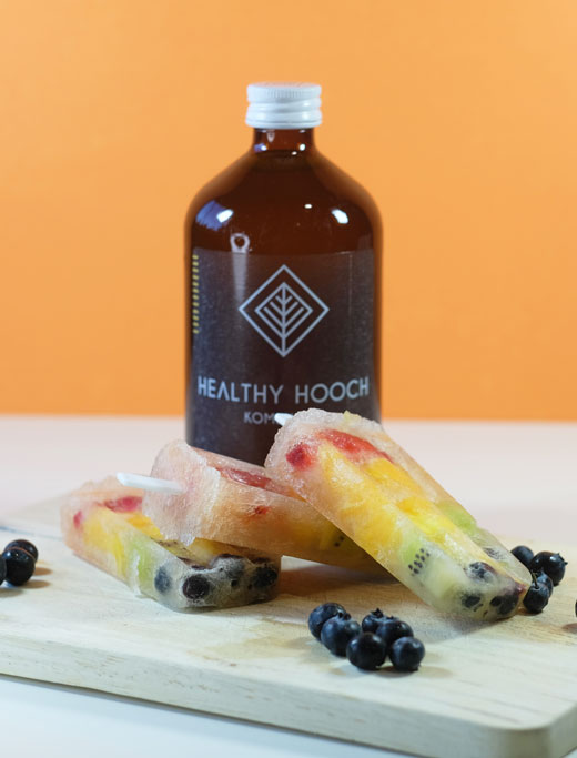 rainbow popsicles next to a bottle of healthy hooch kombucha